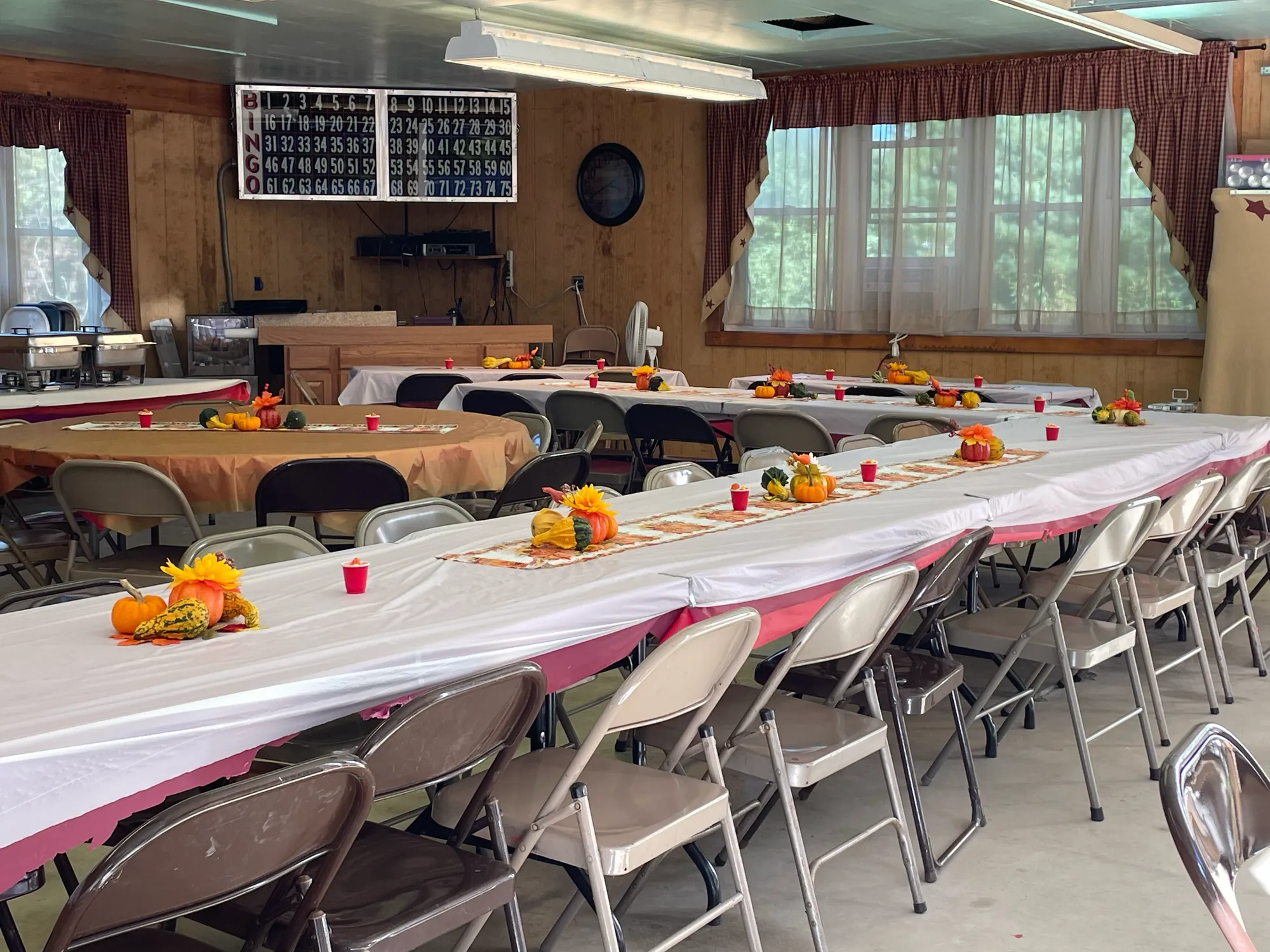 Lodge tables decorated with pumpkins and sunflowers for a fall gathering